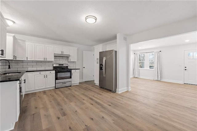 kitchen with sink, appliances with stainless steel finishes, white cabinetry, decorative backsplash, and light wood-type flooring