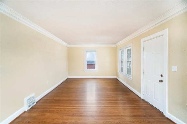 empty room featuring hardwood / wood-style floors and ornamental molding