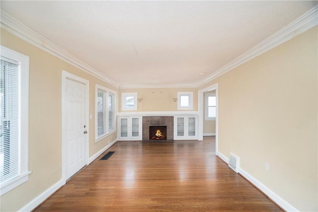 unfurnished living room featuring a tile fireplace, hardwood / wood-style floors, and crown molding