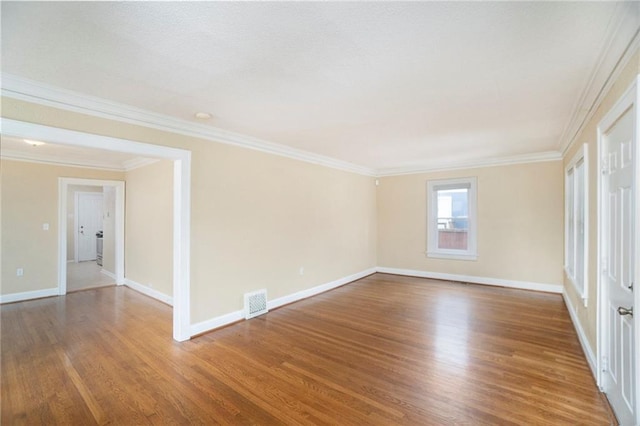 spare room with wood-type flooring and crown molding