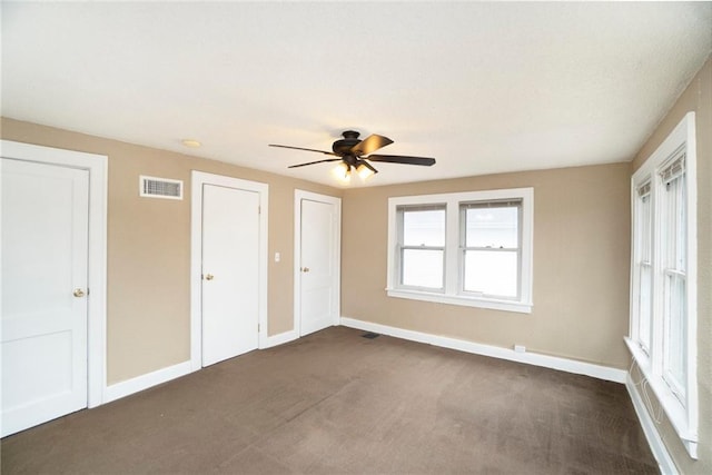 unfurnished bedroom featuring ceiling fan and dark carpet