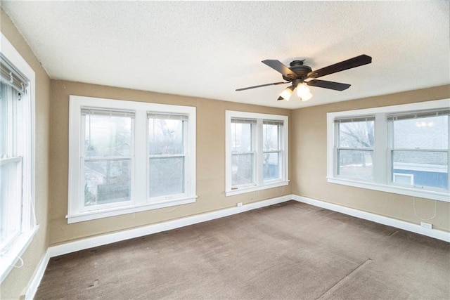 carpeted empty room with ceiling fan and a textured ceiling