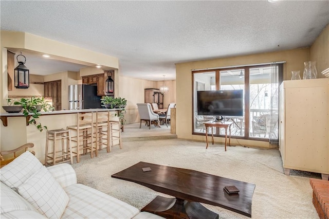 carpeted living room with an inviting chandelier and a textured ceiling