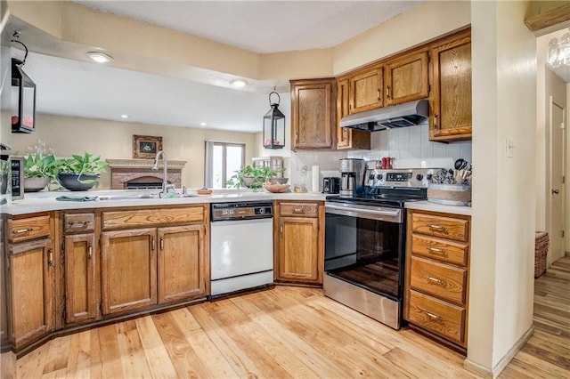 kitchen featuring sink, stainless steel range with electric stovetop, light hardwood / wood-style flooring, dishwasher, and decorative backsplash