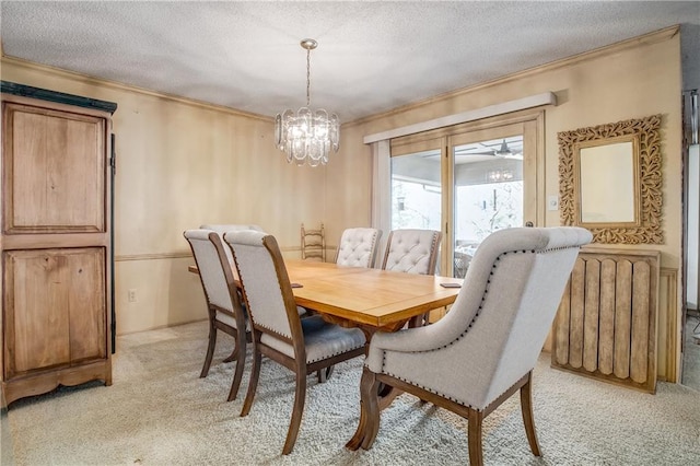 carpeted dining space featuring radiator, ornamental molding, and a textured ceiling