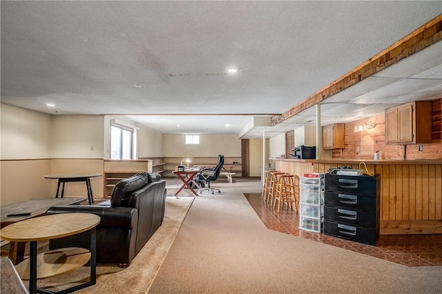 living room with light colored carpet, a textured ceiling, and wood walls