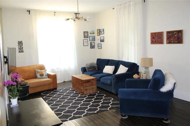 living room with dark hardwood / wood-style floors and an inviting chandelier