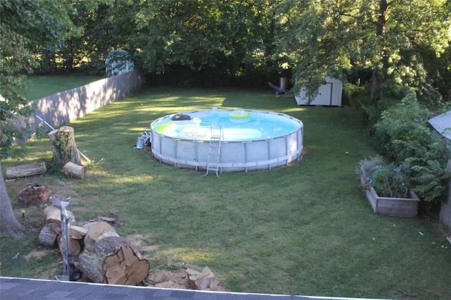 view of yard featuring a fenced in pool and a storage shed