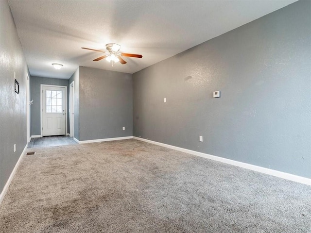 carpeted empty room with a textured ceiling and ceiling fan