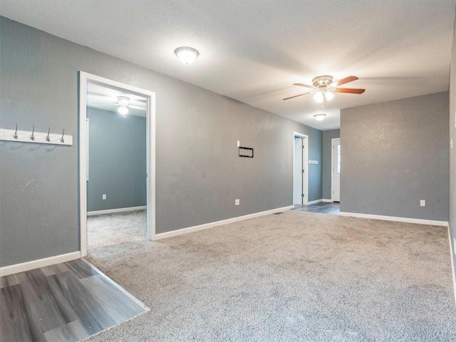 carpeted empty room featuring ceiling fan and a textured ceiling