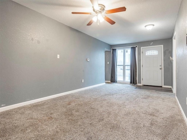 carpeted empty room with a textured ceiling and ceiling fan