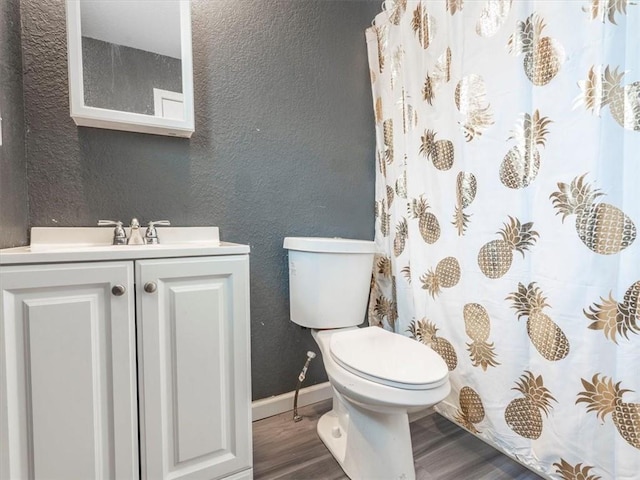 bathroom featuring wood-type flooring, toilet, and vanity