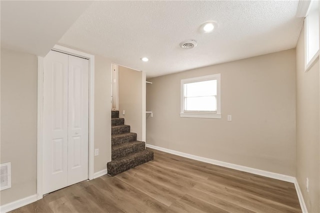 interior space featuring wood-type flooring and a textured ceiling