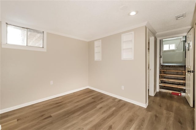 basement with ornamental molding and dark hardwood / wood-style floors