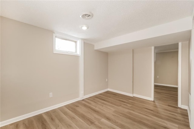 basement with wood-type flooring and a textured ceiling