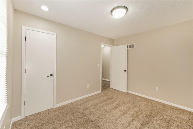 unfurnished bedroom featuring carpet and a textured ceiling