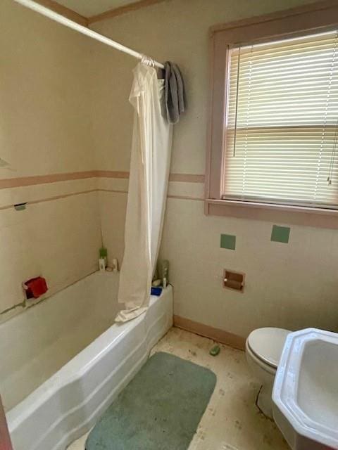 full bathroom with tile walls, sink, toilet, and shower / bath combo with shower curtain