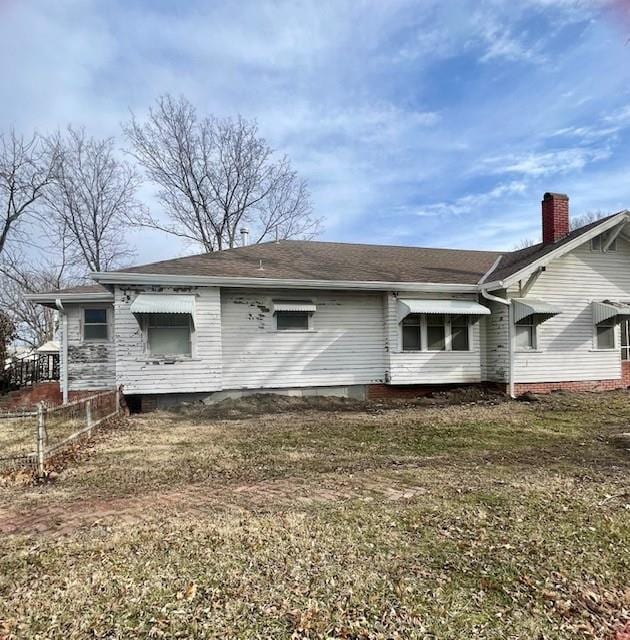 rear view of house featuring a lawn