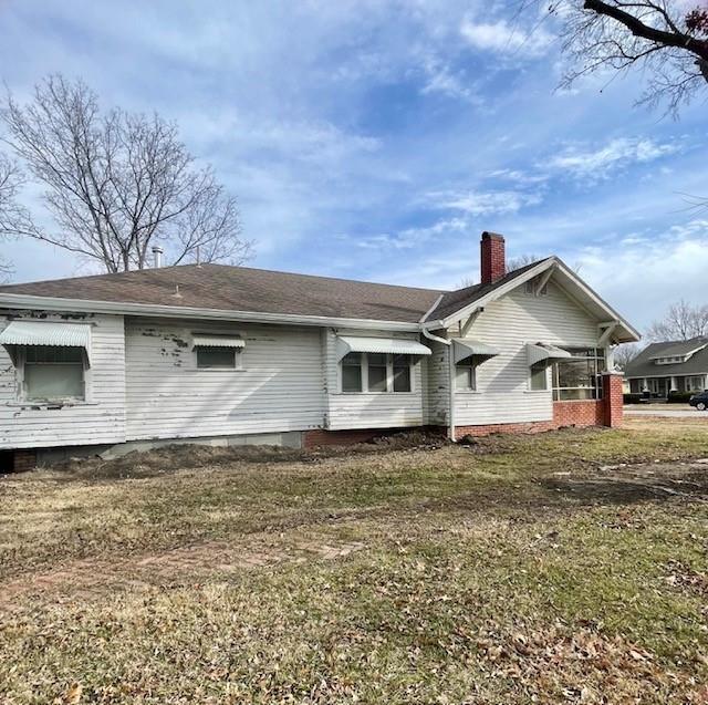 view of side of home with a yard