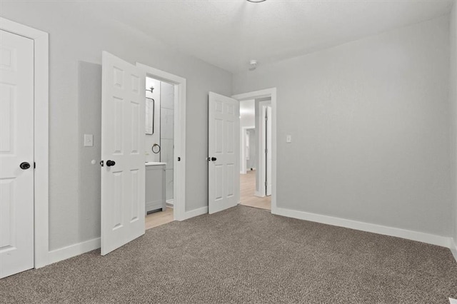 unfurnished bedroom with connected bathroom and carpet floors