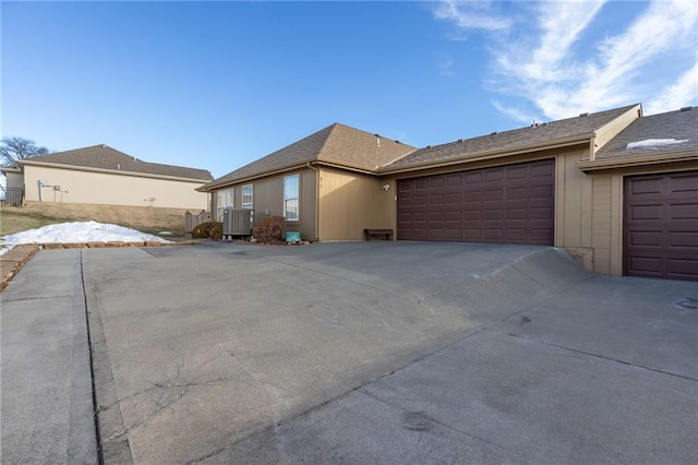 single story home featuring a garage and central air condition unit