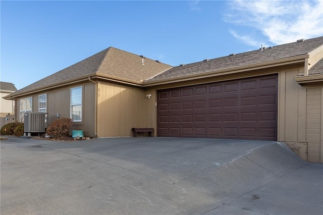 view of home's exterior with a garage and central air condition unit