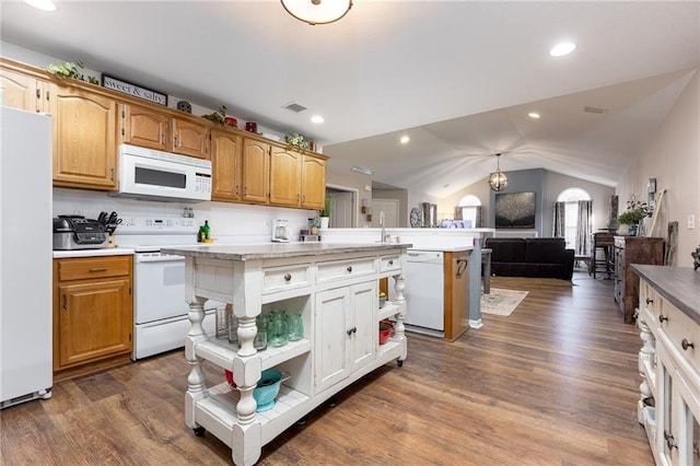 kitchen with white appliances, dark hardwood / wood-style floors, vaulted ceiling, and a kitchen island