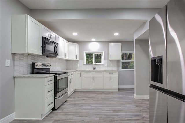 kitchen featuring sink, appliances with stainless steel finishes, light stone countertops, white cabinets, and decorative backsplash