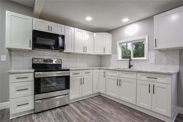 kitchen with white cabinetry, stainless steel electric stove, sink, and light hardwood / wood-style flooring