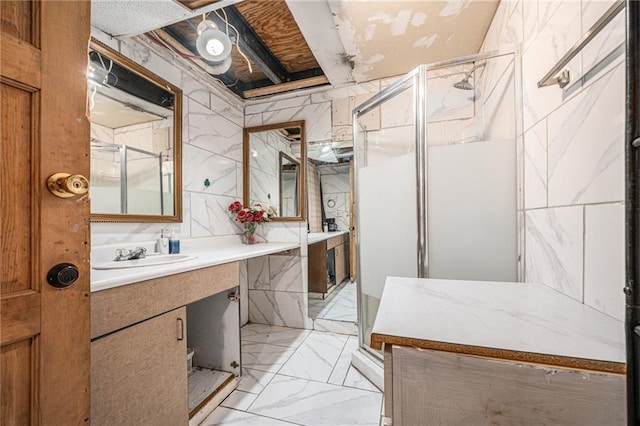 bathroom featuring walk in shower, vanity, and tile walls