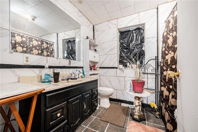 bathroom with vanity, tile walls, walk in shower, and toilet