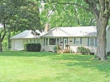 ranch-style home featuring a garage and a front lawn