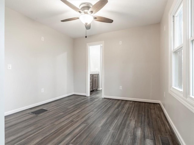 unfurnished room with ceiling fan, plenty of natural light, and dark hardwood / wood-style floors