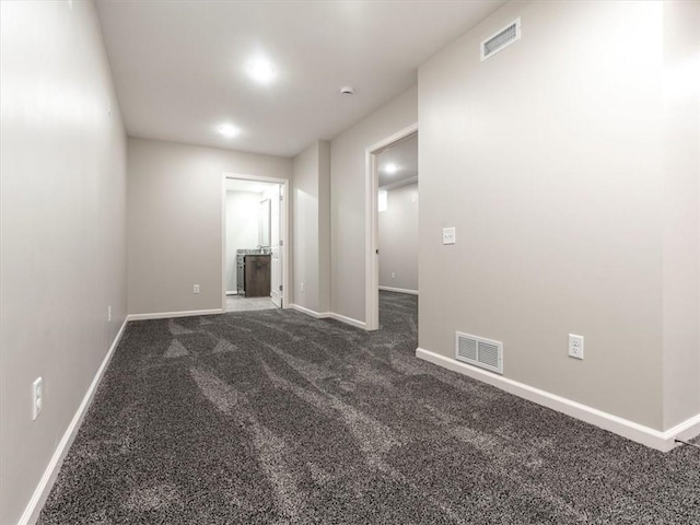 spare room with dark colored carpet