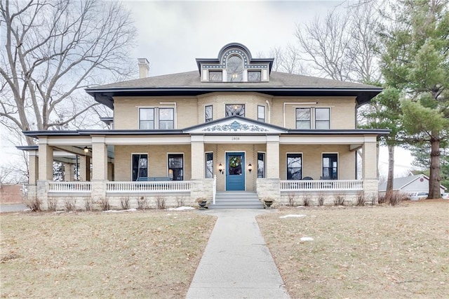 view of front of property with covered porch and a front lawn