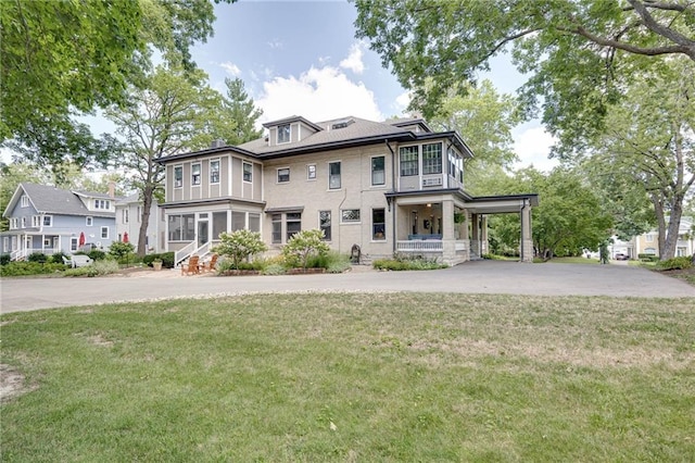 view of front of house with a front lawn, a porch, and driveway