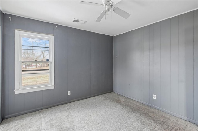 empty room featuring light carpet, a wealth of natural light, and ceiling fan