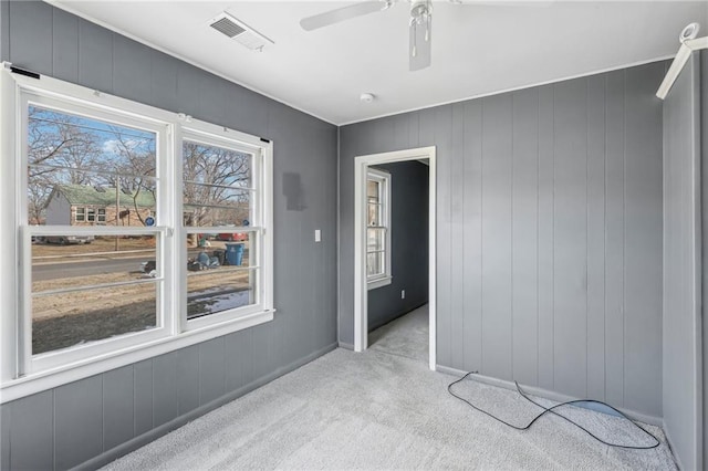 spare room with ceiling fan and light carpet