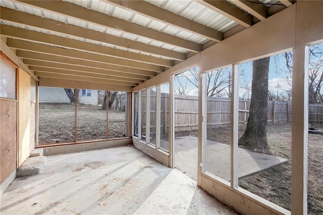 unfurnished sunroom with beam ceiling