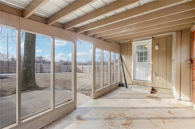 unfurnished sunroom featuring beamed ceiling