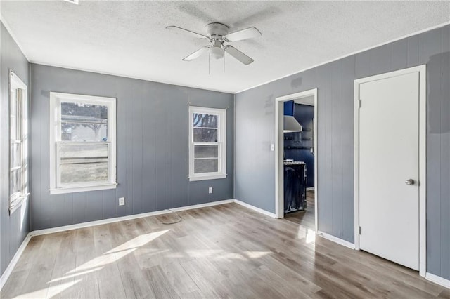 unfurnished room featuring ceiling fan, a textured ceiling, and light hardwood / wood-style flooring