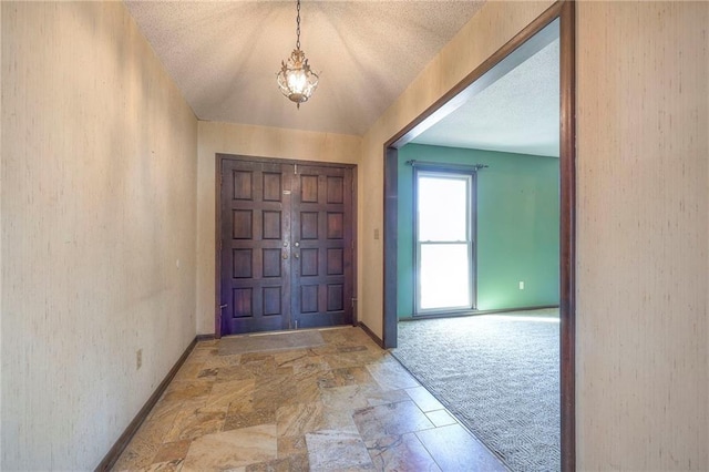 foyer with carpet floors and a textured ceiling