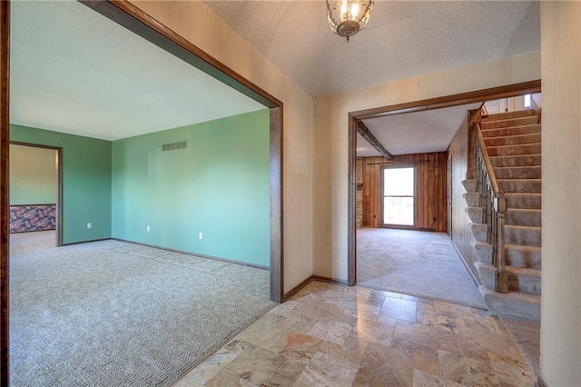 carpeted entryway featuring a textured ceiling