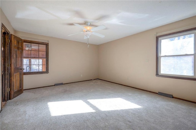 spare room featuring light colored carpet and ceiling fan