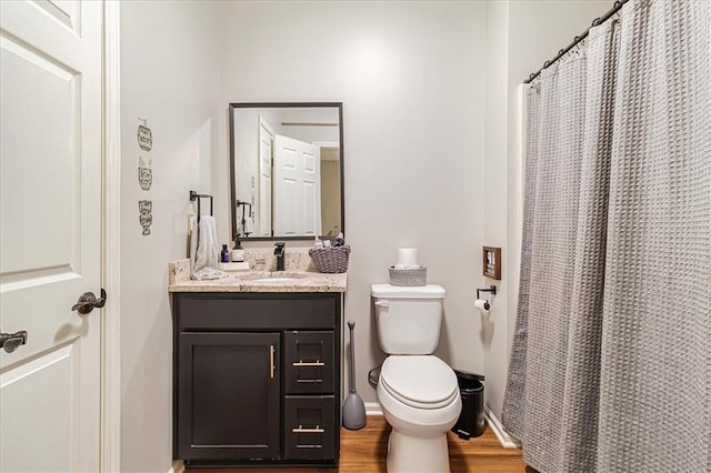 bathroom featuring vanity, hardwood / wood-style flooring, toilet, and walk in shower