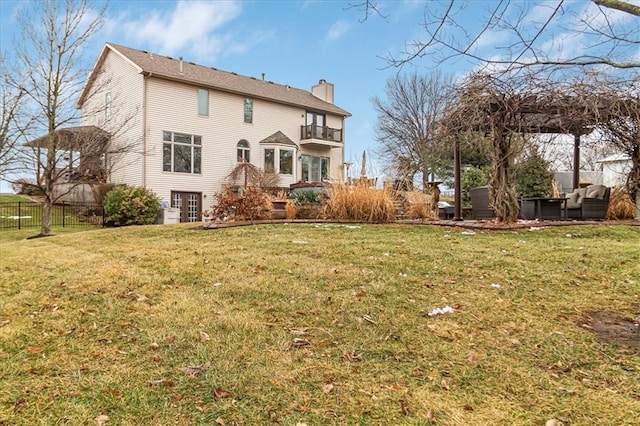 back of house featuring a lawn, outdoor lounge area, and a balcony