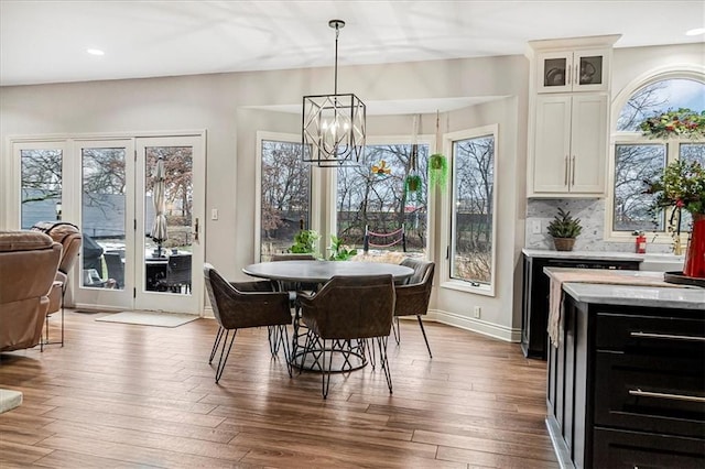 dining room with hardwood / wood-style floors and an inviting chandelier