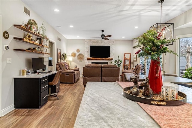 living room with ceiling fan and light wood-type flooring