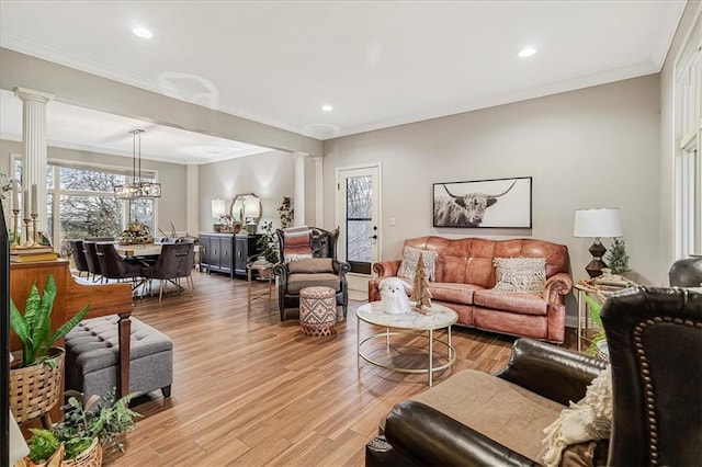 living room with ornamental molding, light hardwood / wood-style flooring, and ornate columns