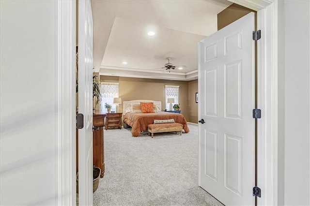 carpeted bedroom with a raised ceiling